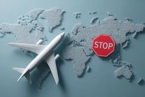 Airplane travel ban symbol with stop sign over world map