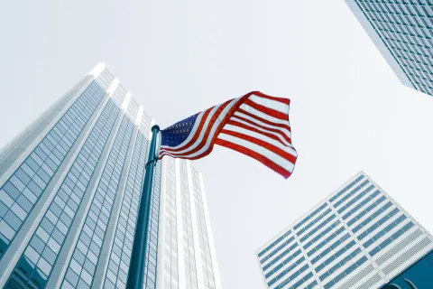 USA flag on pole in city