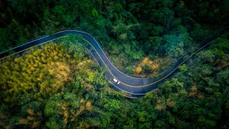 Aerial shot of car on windy road.