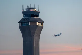 ATC Tower with airplane flying in distance