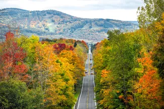 West Virginia road highway with many cars traffic in colorful autumn fall near Blackwater Falls State park and Seneca Rocks with steep ski resort slope hill