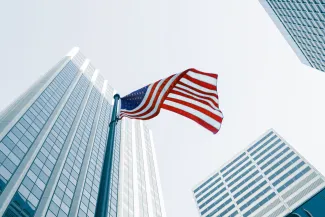 USA flag on pole in city