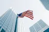 USA flag on pole in city